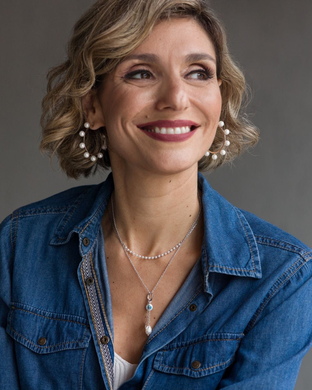 Woman wearing a blue denim shirt with a neutral background